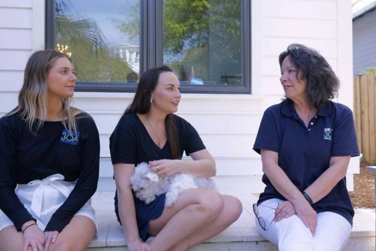 Grayt 30A team members Jorgi, Christie, and Jerri sitting and talking on a porch Grayt 30A team members Jorgi, Christie, and Jerri sitting and talking on a porch